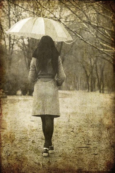 Chica solitaria con maleta y paraguas en camino rural. — Stok fotoğraf