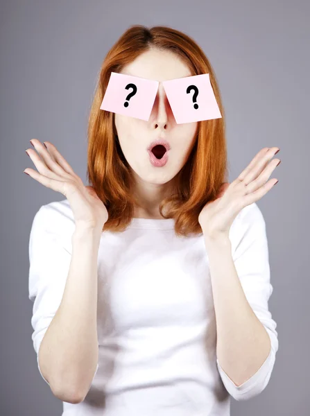 Redhead girl with stickers and questions. Studio shot. — Stock Photo, Image