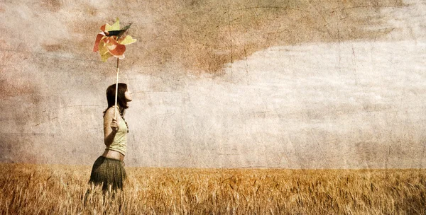 Chica con turbina eólica en el campo de trigo. Foto en imagen a color antiguo —  Fotos de Stock