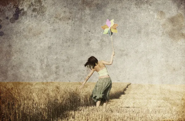 Девушка с ветровой турбиной на пшеничном поле. Фото в старом цветном изображении — стоковое фото