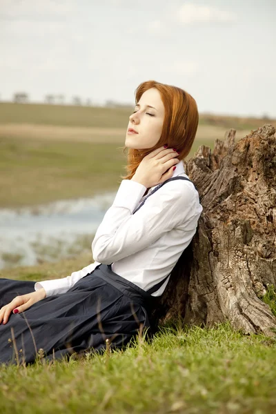그 루터 기 근처 녹색 잔디에 앉아 여자. — 스톡 사진