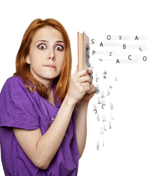 Redhead girl hiding behind a book of flying letters. — Stock Photo, Image