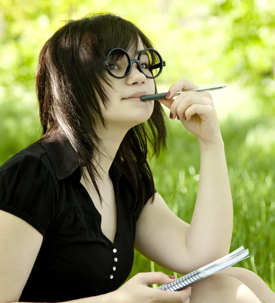年轻少女与笔记本在绿草. — 图库照片