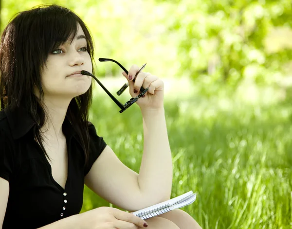 Fiatal tini lány a notebook-on zöld fű. — Stock Fotó