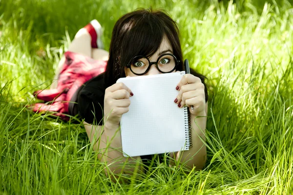 Jeune adolescente avec ordinateur portable à l'herbe verte . — Photo