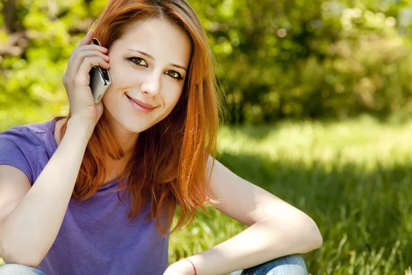 移动电话在夏天 t 公园的美丽的红发女孩 — 图库照片
