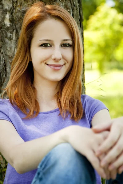 Όμορφη κοκκινομάλλα κοπέλα στο πάρκο το καλοκαίρι. — Φωτογραφία Αρχείου