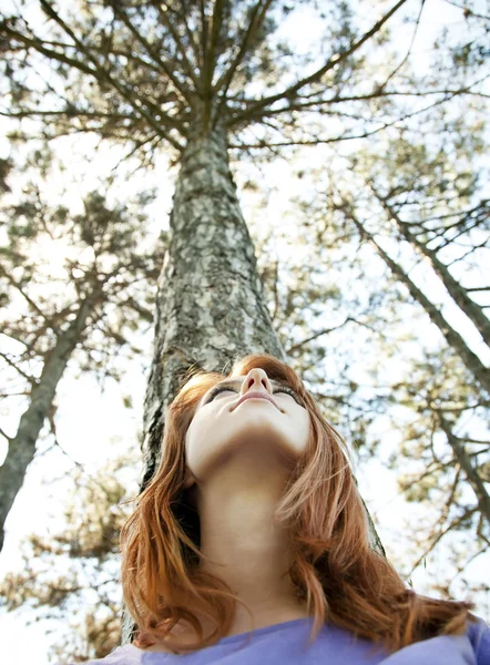 Beautiful redhead girl at the park in summer time looking up. — Stock Photo, Image