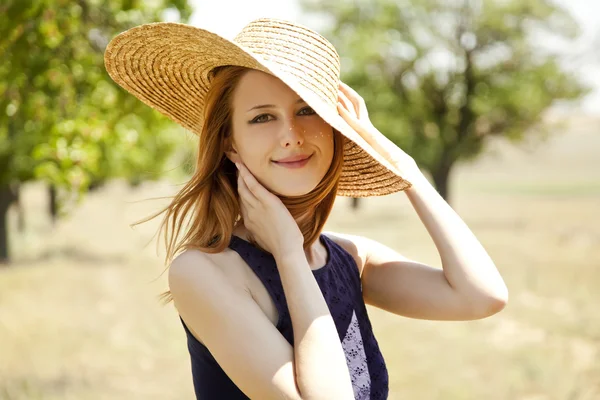 Porträtt av rödhårig flicka i hatt på landsbygden. — Stockfoto
