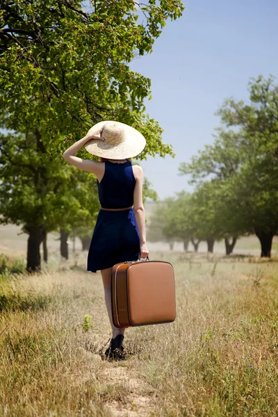 Lonely girl with suitcase at countryside. — Stock Photo, Image