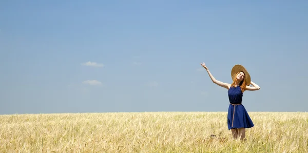 Rödhårig flicka på vårvete fält. — Stockfoto