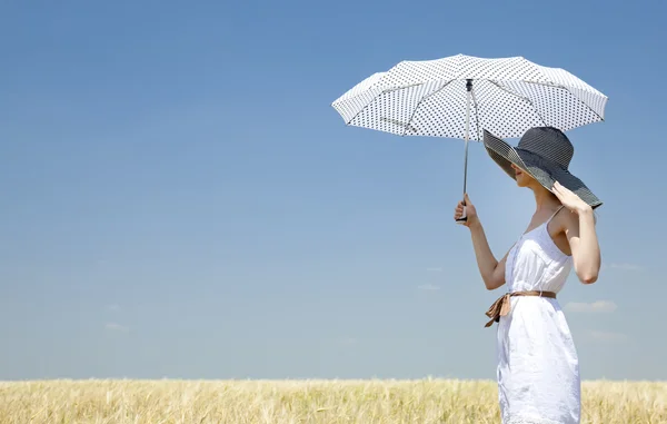Rusovláska dívka na jaře pole s deštníkem. — Stock fotografie