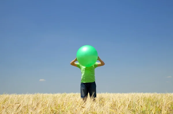 밀밭에서 녹색 공 가진 남자. — 스톡 사진