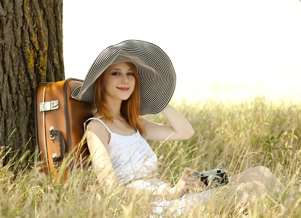 Vintage fotoğraf makinesi ile ağacın yanında oturan Kızıl saçlı kız. — Stok fotoğraf