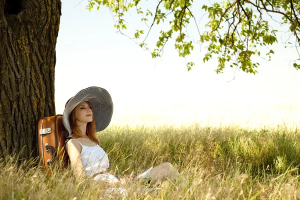 ビンテージ カメラで木の近くに座っている赤毛の女の子. — ストック写真