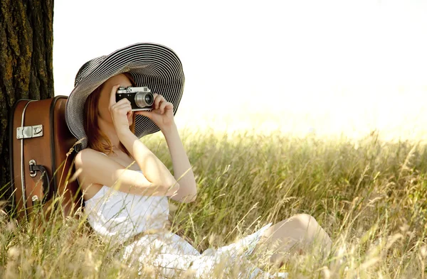 ビンテージ カメラで木の近くに座っている赤毛の女の子. — ストック写真