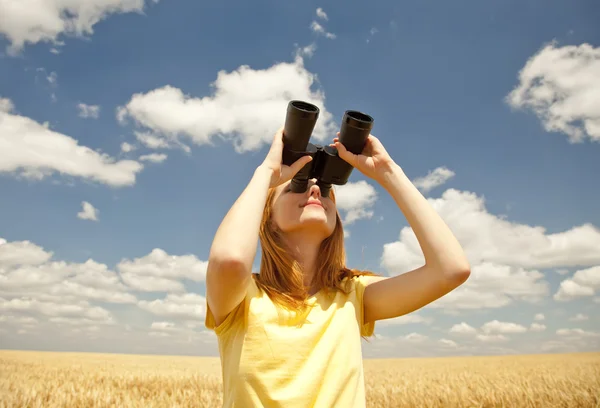Redhead girl with binocular at wheat field. — Stock Photo, Image