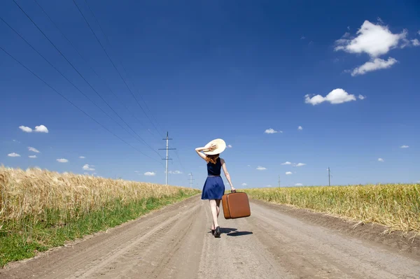 Magányos lány, bőrönd, ország út. — Stock Fotó