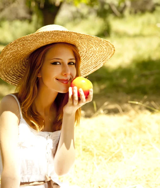 Beautiful redhead girl with fruit at garden. — Stockfoto