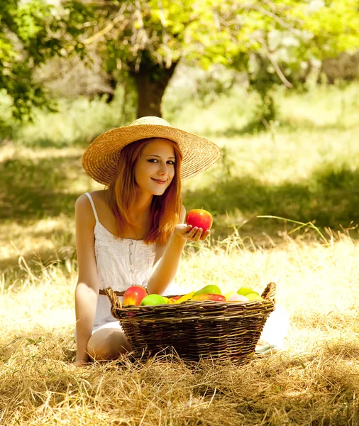Beautiful redhead girl with fruits in basket at garden. — Stock Photo, Image