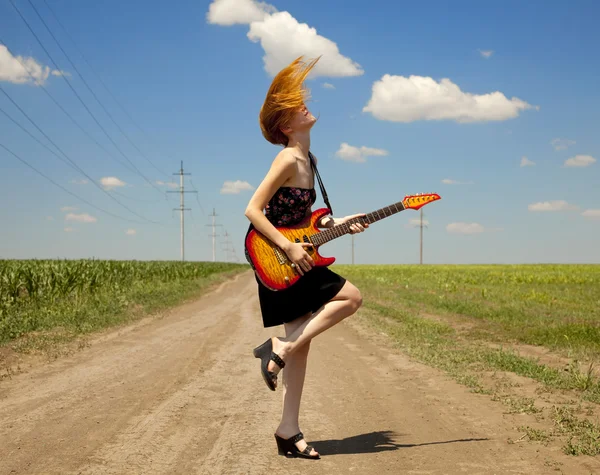 Rocková dívka s kytarou v krajině. — Stock fotografie