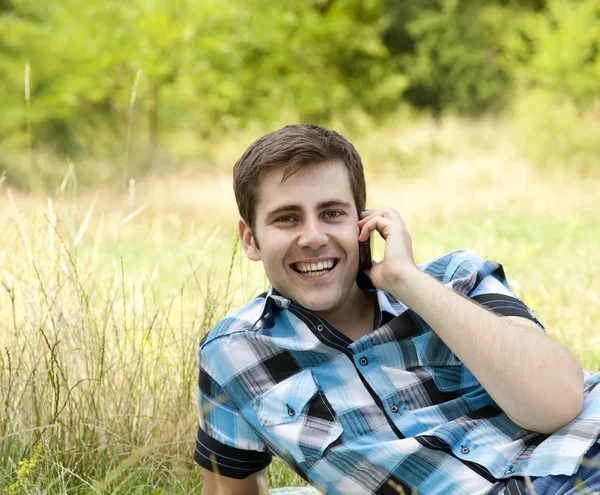 Uśmiechający się ludzie z telefonu komórkowego na zewnątrz. — Zdjęcie stockowe