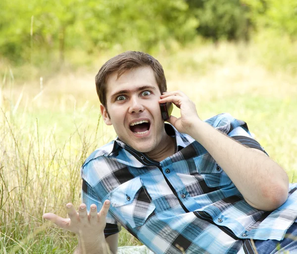 Verrast mannen met mobiele telefoon bij buiten. — Stockfoto