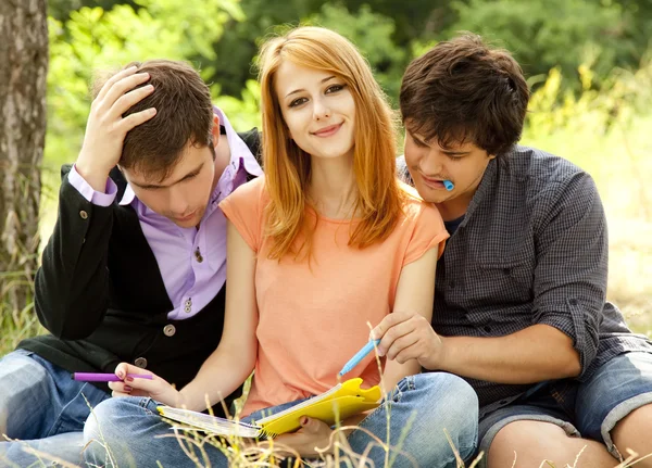 Three students at outdoor doing homework. — Stock Photo, Image
