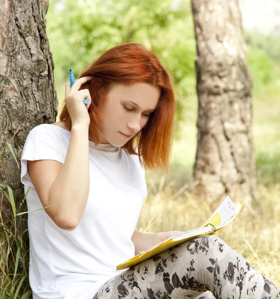 야외에서 숙제를 하 고 빨간 머리 소녀. — 스톡 사진