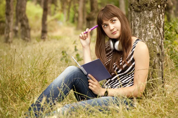 Mladá dospívající dívka dělat úkoly v parku. — Stock fotografie