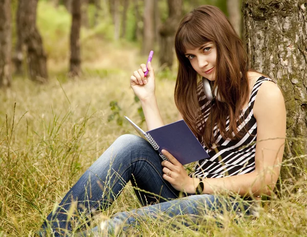 Jonge tiener meisje huiswerk in het park. — Stockfoto