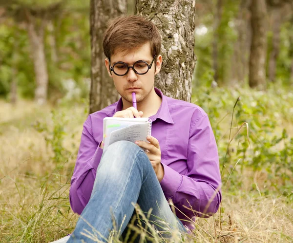 Funny men with glasses doing homework at the park. — Stock Photo, Image