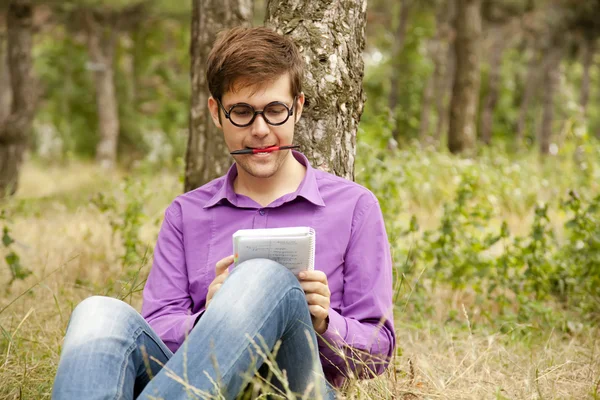Des hommes drôles avec des lunettes faisant leurs devoirs au parc . — Photo