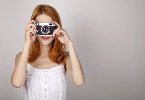 Rödhårig flicka i vit klänning med vintage kamera. — Stockfoto