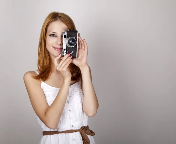 Rusovláska dívka v bílých šatech s vinobraní fotoaparát. — Stock fotografie