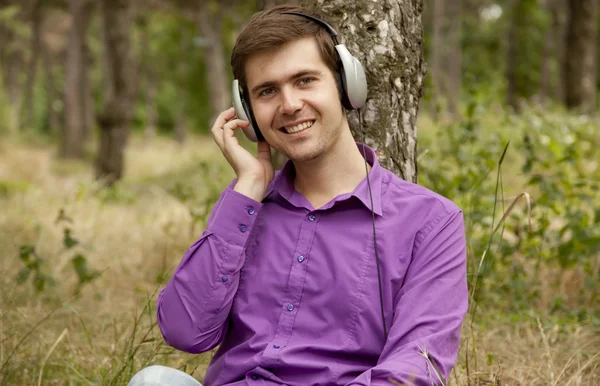 Männer mit Kopfhörern im Park. — Stockfoto
