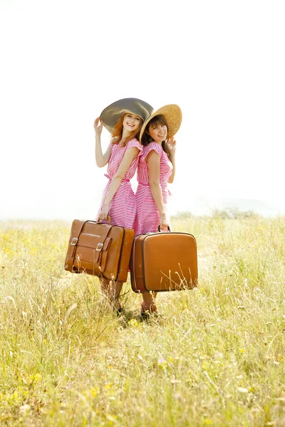 Zwei Mädchen im Retro-Stil mit Koffern auf dem Land. — Stockfoto