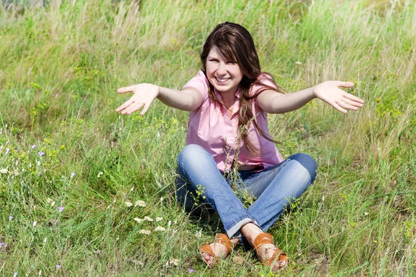 Meisje op groen gras op het platteland. — Stockfoto
