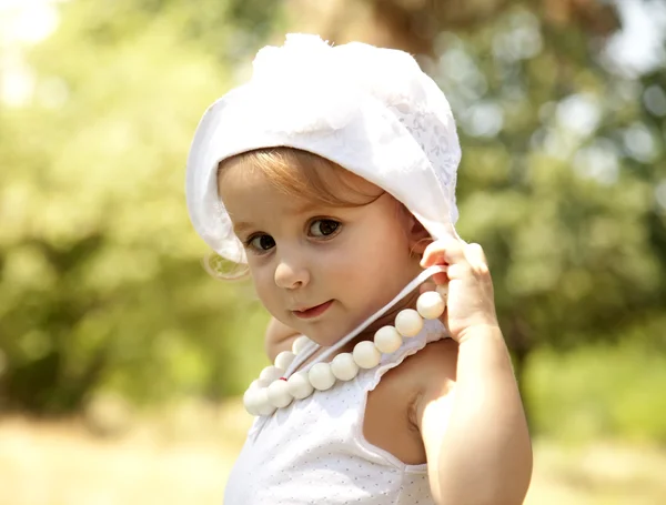 Nettes kleines Mädchen lächelt in einem Park — Stockfoto
