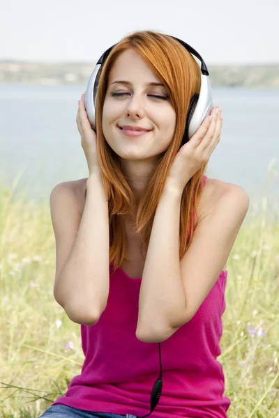 Rude dziewczyny z słuchawek w parku. — Zdjęcie stockowe