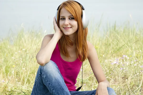 耳机在公园里的红发女孩. — 图库照片