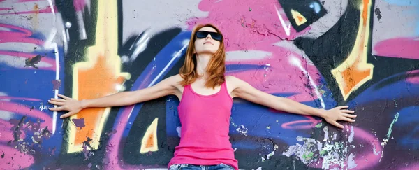 Graffiti duvar yakınındaki kaykay ile stil kız. — Stok fotoğraf