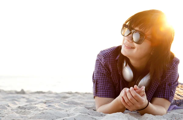 바닷가 모래에서 헤드폰으로 아름 다운 갈색 머리 소녀. — 스톡 사진