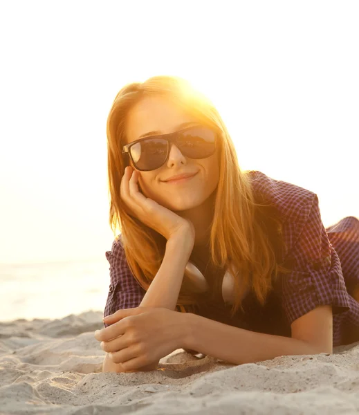Kulaklıklar, sahil kumu ile güzel kızıl saçlı kız. — Stok fotoğraf