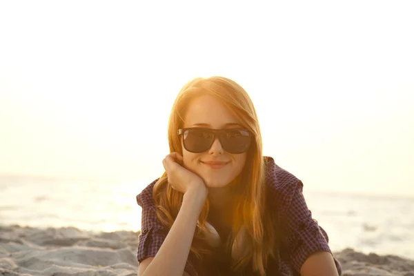 Красива руда дівчина з навушниками на пляжному піску . — стокове фото