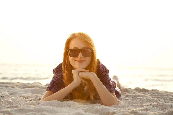 美丽的红发女孩用耳机在沙海滩. — 图库照片