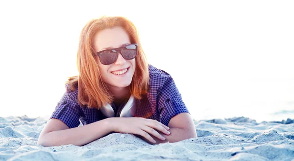 Kulaklıklar, sahil kumu ile güzel kızıl saçlı kız. — Stok fotoğraf