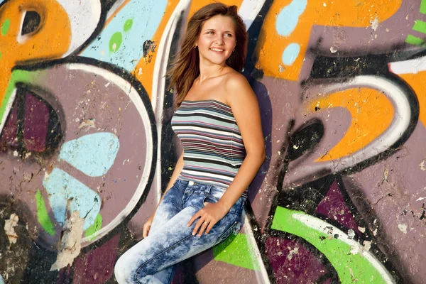 Όμορφη μελαχρινή κοπέλα με κιθάρα και γκράφιτι τοίχο στο backgro — Φωτογραφία Αρχείου