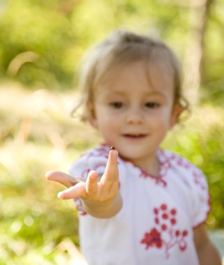 Little girl in traditional ukrainian costume on green grass at t clipart