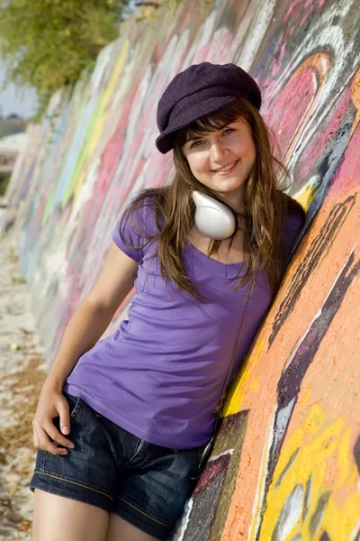 Szép barna lány, a fejhallgató és a graffiti fal bac — Stock Fotó